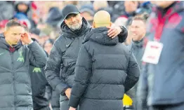  ?? ?? Liverpool’s manager Jurgen Klopp (centre) hugs Manchester City’s head coach Pep Guardiola after the English Premier League match between Liverpool and Manchester City at Anfield stadium in Liverpool, England, yesterday.