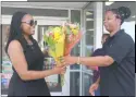  ??  ?? Spring Dell Center staff member Alice King gave flowers to Hyattsvill­e resident Jasmine Haynes at the Wawa in White Plains on Oct. 19, in honor of National Petal it Forward Day.