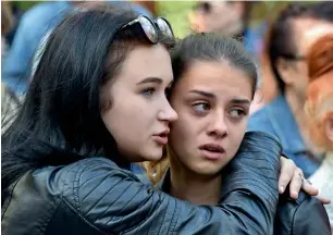  ?? AFP ?? Two girls attend a church service for the victims of the college attack in Kerch, Crimea. —