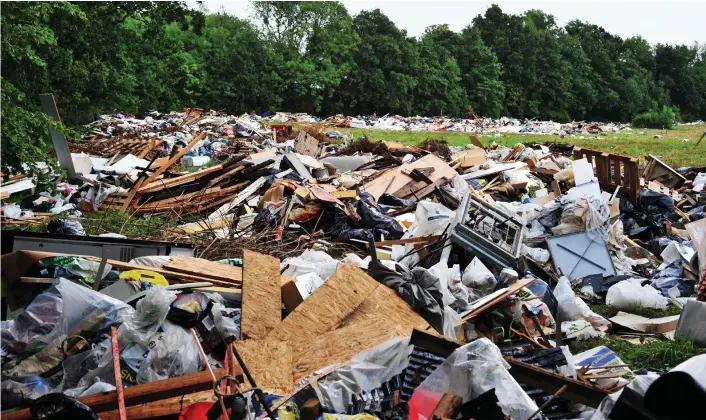  ??  ?? Mountain of waste: Huge piles of rubbish, which will cost £100,000 to clear, were discarded by travellers before they left the field in Bromley, near London