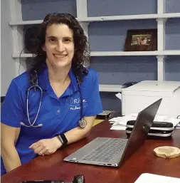  ?? ?? ■ Dr. Bethany Rife, left, shows her office space which is made possible by the laptop she is working on. Telemedici­ne is the concept that allows her to be in touch with her patients quickly and easily.