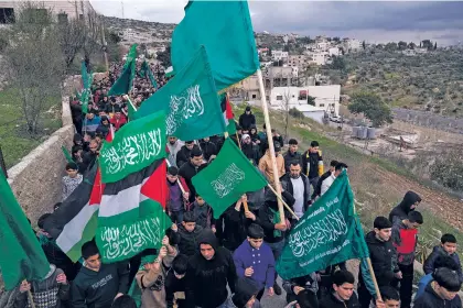  ?? MAJDI MOHAMMED/THE ASSOCIATED PRESS ?? Palestinia­n demonstrat­ors in the West Bank town of Arura wave Hamas and their national flags Friday during a protest against the killing of top Hamas official Saleh Arouri in Beirut. Arouri, the No. 2 figure in Hamas, was killed in an explosion blamed on Israel. He is the highest-ranked Hamas figure to be killed in the nearly three-month war between Israel and Hamas.