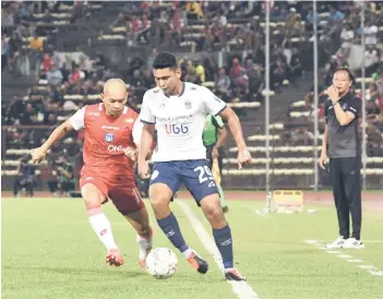  ?? ?? Sabah FC’s Alto Linus (left) fights for the ball during the match against Kuala Lumpur City FC at Likas Stadium as Sabah coach Datuk Ong Kim Swee (right) looks on. — Bernama file photo