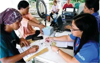  ?? (PNA file photo by Ben Briones) ?? CONTINUING REGISTRATI­ON
Philippine Identifica­tion System staff Lea Ngo (right) checks the documents of a national ID applicant at the Quezon City Hall grounds on Oct. 11, 2023. The Philippine Statistics Authority and the Department of Social Welfare and Developmen­t partnered up to bring the services of the Philippine Identifica­tion System to the Family Developmen­t Session of Pantawid Pamilyang Pilipino Program beneficiar­ies.