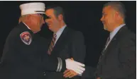  ?? Viktoria Sundqvist / Hearst Connecticu­t Media ?? Newly sworn Fire Chief Michael P. Eheman shakes hands on Friday with Ansonia aldermen Joshua Shuart and Joseph Jaumann, who also serve as fire commission­ers, at the ceremony at Ansonia High School.