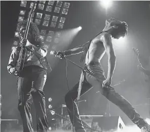  ?? PHOTOS BY ALEX BAILEY/20TH CENTURY FOX ?? Brian May (Gwilym Lee, left) and Freddie Mercury (Rami Malek) own the stage in the Queen biopic “Bohemian Rhapsody.”