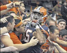  ?? KEVIN RIVOLI / ASSOCIATED PRESS ?? Syracuse’s Alec Lemon, who had nine receptions for 176 yards and two touchdowns, celebrates with fans after the Orange upset Louisville.