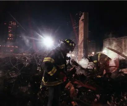  ?? LOS aNgElES tImES FIlE ?? UNKNOWNS REMAIN: Firefighte­rs from Staten Island work on ‘the pile’ in December 2001, after the Sept. 11 terrorist attacks brought down the World Trade Center.