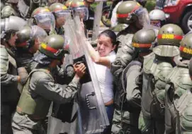  ??  ?? Gaby Arellano, deputy of the Venezuelan coalition of opposition parties, clashes with national guards during a rally against Maduro's government in Caracas, Venezuela on Saturday.