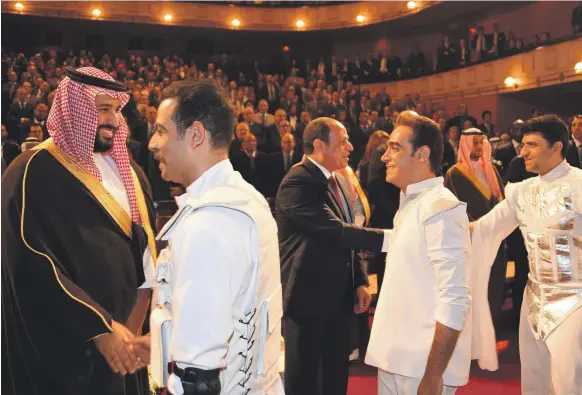  ??  ?? Egyptian President Abdel Fattah El Sisi and Saudi Crown Prince Mohammed bin Salman shake hands with performers after a concert in Cairo’s Opera House