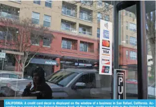  ?? ?? CALIFORNIA: A credit card decal is displayed on the window of a business in San Rafael, California. According to a report by the Federal Reserve Bank of New York, credit card debt in the United States has reached $1.13 trillion. — AFP