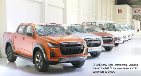  ?? ?? BRAND-new light commercial vehicles line up the hall of the new dealership for customers to check.