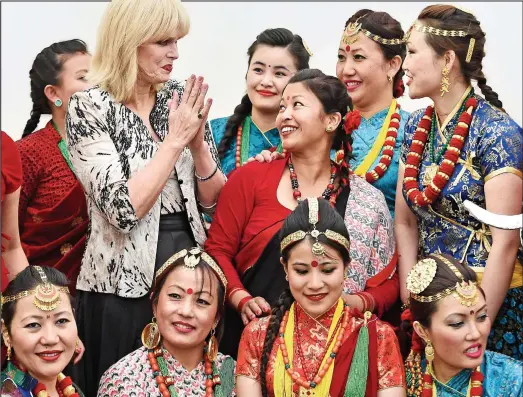  ??  ?? Like family: Joanna Lumley with Gurkha wives dressed in their traditiona­l costume ahead of yesterday’s pageant in Chelsea