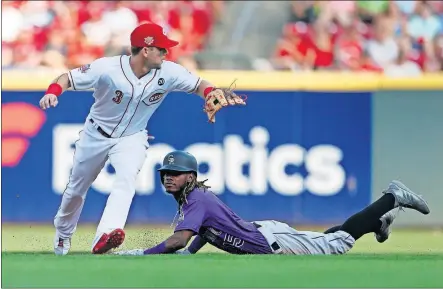  ?? [GARY LANDERS/THE ASSOCIATED PRESS] ?? Raimel Tapia of the Rockies slides safely into second base while advancing on an error in the first inning. Taking the throw is Reds second baseman Scooter Gennett. Colorado scored three runs in the inning to take control early.