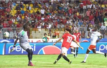  ??  ?? Egypt’s Mohamed Salah (centre) scores a goal against Niger’s goalkeeper Kassaly Daouda (left) during the Africa Cup of Nations qualifier match between Egypt and Niger in Borg el-Arab stadium near the Mediterran­ean city of Alexandria. — AFP photo