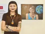  ??  ?? Painter and tattoo collector Cleng Sumagaysay with her portrait “At the Forefront of an Archaic Yet Seemingly New Paradigm.” Cleng has brought to her hometown new things she learned from California’s vibrant arts scene.