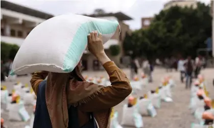  ?? Photograph: Khaled Abdullah/Reuters ?? A worker carries a sack of wheat flour during the distributi­on of food aid by the local charity, Mona Relief, in Sana’a, Yemen.