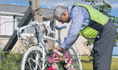  ?? RYAN ROSS/THE GUARDIAN ?? Edmund Aunger places a wreath on the bike he was riding the day his wife, Elizabeth Sovis, was killed by a drunk driver during a cycling trip in P.E.I. in 2012. Aunger held a memorial service in Hunter River on Friday to mark the five-year anniversar­y...