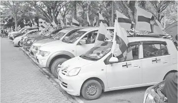  ??  ?? Vehicles bearing old Sarawak flags line up at the parking lot of Miri Civic Centre.