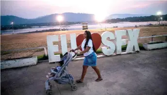  ?? ?? A woman walks with a toddler along a promenade in front of the banks of the Xingu River during sunset at the city of Sao Felix do Xingu, Para state, Brazil