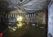  ?? MAX BECHERER / THE ADVOCATE ?? A flashlight illuminate­s the main command center of a Cold War-era Civil Defense bunker in New Orleans. The fallout shelters were set up in tens of thousands of buildings nationwide in the early 1960s amid the nuclear arms race.