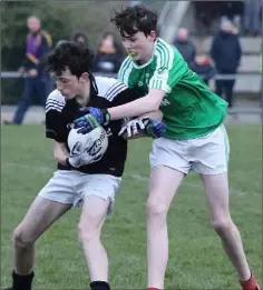  ??  ?? Shane Curran of St. Joseph’s holds off the challenge of Kilmore centre-forward Lewis Cosgrave.