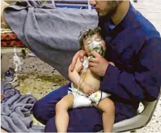  ?? Foto: dpa ?? Ein Sanitäter hilft nach dem Angriff in Duma einem Kleinkind mit einer Atemmaske. Wurde es Opfer von Giftgas? Das Foto wurde von den „Weißhelmen“, einer nicht staatliche­n Zivilschut­zorganisat­ion in Syrien, zur Verfügung gestellt.