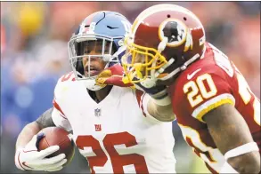  ?? Rob Carr / Getty Images ?? Saquon Barkley of the Giants stiff-arms strong safety Ha Ha Clinton-Dix of the Washington Redskins in the first half at FedExField on Sunday in Landover, Md.