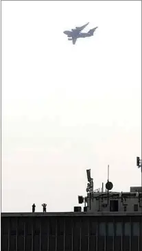  ?? ALEX HORVATH / THE CALIFORNIA­N ?? A C-17 Globemaste­r from Edwards Air Force Base soared over Bakersfiel­d on Friday as part of an extended flyover of several military aircraft. Two people can be seen watching from the roof of the Kern County Superior Court building in the distance.