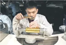  ?? ?? A jewellery cra sman working on a gold product at the Chow Tai Fook Jewellery Creative Centre.