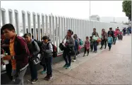  ??  ?? This July 26, photo shows people lining up to cross into the United States to begin the process of applying for asylum near the San Ysidro port of entry in Tijuana, Mexico.