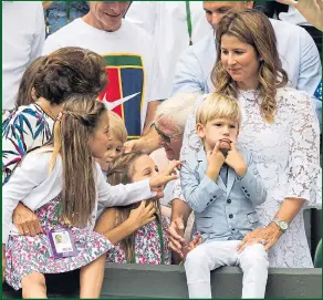  ??  ?? One of Roger Federer’s four children pulls a face at Wimbledon yesterday. The star, holding the trophy, is overcome with emotion as he waves to them