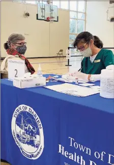  ?? Contribute­d photos / Town of Darien ?? A care worker registers a patient for a COVID-19 vaccinatio­n at a clinic held by the Town of Darien this week. Health care workers vaccinated 110 people this week, and the town has clinics scheduled for Tuesday and Wednesday. Local teachers expressed frustratio­n and said they found the process confusing. Vaccine is limited to those over 75 years old and appointmen­ts are required.