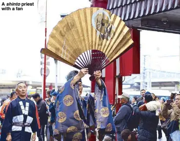  ??  ?? A shinto priest with a fan