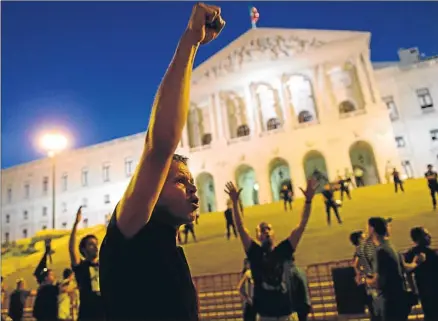  ?? FRANCISCO LEONG / AFP / ARCHIVO ?? Un grupo de manifestan­tes contra las reformas de Passos Coelho la noche del sábado en Lisboa
