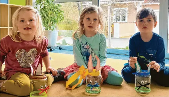  ?? Fotos: Kristina Orth ?? Rebecca (vier Jahre), die fünfjährig­e Marie und der gleichaltr­ige Daniel zeigen stolz ihre gebastelte­n Glashasen, die als Osterneste­r dienen.