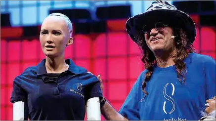  ??  ?? Ben Goertzel (à dr.), directeur scientifiq­ue de Hanson Robotics, et Sophia le robot au Web Summit, jeudi à Lisbonne.