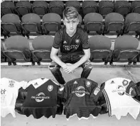  ?? MARK THOR/ORLANDO CITY ?? Defender Michael Halliday, who just signed a Homegrown deal with Orlando City, shows off jerseys he has worn through the years in the Lions’ developmen­tal system.