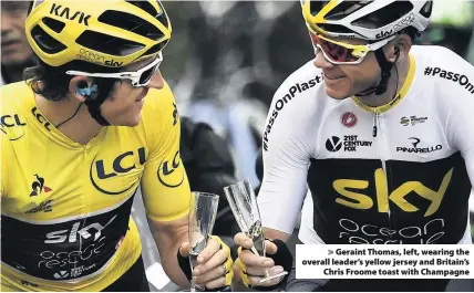  ??  ?? &gt; Geraint Thomas, left, wearing the overall leader’s yellow jersey and Britain’s Chris Froome toast with Champagne