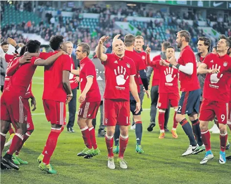  ?? FOTO: DPA ?? Titeltanz: Die Bayern-Spieler feiern nach dem 6:0 in Wolfsburg auf dem Rasen mit passendem T-Shirt die fünfte Meistersch­aft in Folge.
