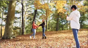  ?? Tyler Sizemore / Hearst Connecticu­t Media ?? From left, Katherine Chinchilla, 18, and her mother, Mildia Chinchilla, enjoy the fall foliage as her brother, Jefferson Chinchilla, 13, takes a photo of them at Bruce Park in Greenwich on Oct. 27, 2020.