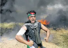  ?? Picture: REUTERS ?? FACING THE GUNS: A Palestinia­n demonstrat­or reacts during clashes with Israeli troops at the Israel-Gaza border, in the southern Gaza Strip