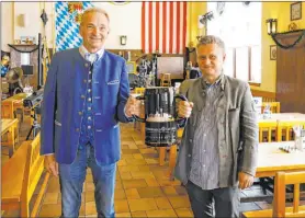  ?? ?? Stefan Gastager, left, president of Hofbräuhau­s Las Vegas, and Franz Krondorfer, vice president, pose holding a specialedi­tion, 170-ounce German beer stein at their restaurant.