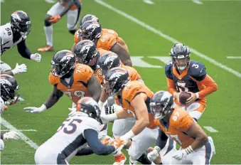  ?? Andy Cross, The Denver Post ?? Broncos quarterbac­k Drew Lock ( 3) takes a snap during training camp at Empower Field at Mile High on Saturday.