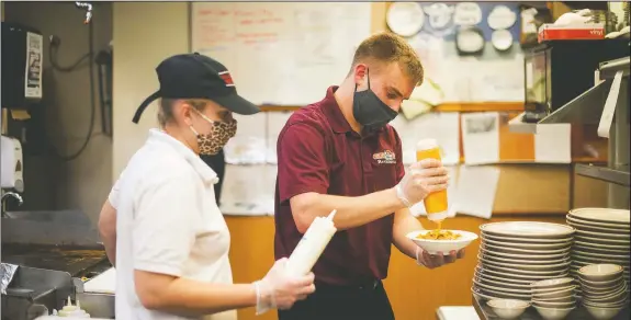  ??  ?? Valley Dairy employee Jen House and manager Alex Blystone (right) work on burrito bowl orders for their ghost kitchen business, Taco Joe’s, at Valley Dairy Restaurant in Latrobe, Pa. (Pittsburgh Tribune-Review/Shane Dunlap)