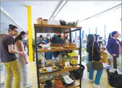  ?? NELVIN C. CEPEDA U-T ?? Customers shop for gently used dining and kitchen items at Kitchens for Good’s new retail space in Pacific Beach on Saturday.