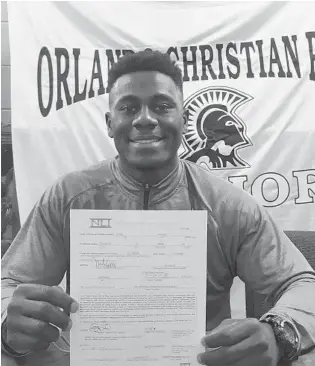  ?? STEPHEN RUIZ/ORLANDO SENTINEL PHOTOS ?? Linebacker Peter Agabe, a native of Nigeria, holds up his signed national letter of intent to play football at Charlotte. He signed on Wednesday, Dec. 19, at his former high school, Orlando Christian Prep.