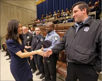  ?? STUART CAHILL — BOSTON HERALD ?? Mayor Michelle Wu congratula­tes a group of municipal guards and BPD officers for their efforts to save a person who had a heart attack. It was part of yesterday’s city council hearing that saw Wu win with two pet projects.