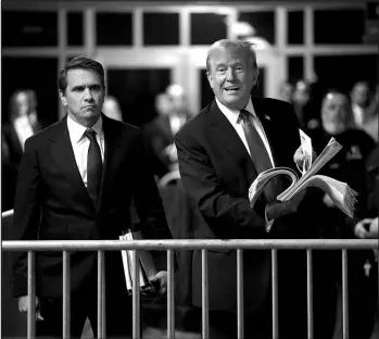  ?? TIMOTHY A. CLARY / POOL PHOTO VIA ASSOCIATED PRESS ?? Former President Donald Trump holds up news clippings as he speaks Thursday following his trial at Manhattan criminal court in New York.