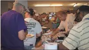  ?? Diane Wagner / Rome News-Tribune ?? Dan Daniel (right), president of the Southeaste­rn Bluegrass Associatio­n, helps himself to food Thursday at the potluck dinner kicking off the Labor Day bluegrass festival.